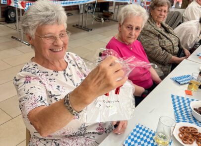 Bewohnerin hat ein Geschenk in der Hand und lächelt