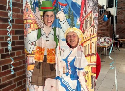 Zwei Bewohner posieren hinter einem Oktoberfest-Vorhang