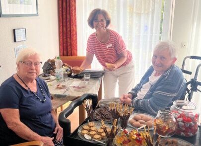 Zwei Bewohnerinnen, eine Mitarbeiterin vor dem Candywagen
